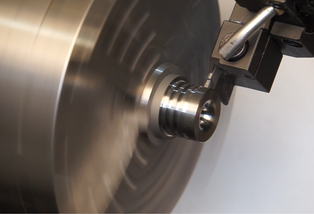 A close-up of a CNC machine groove turning a carbide component, demonstrating how precision engineering can maximise efficiency and minimise costs in manufacturing.