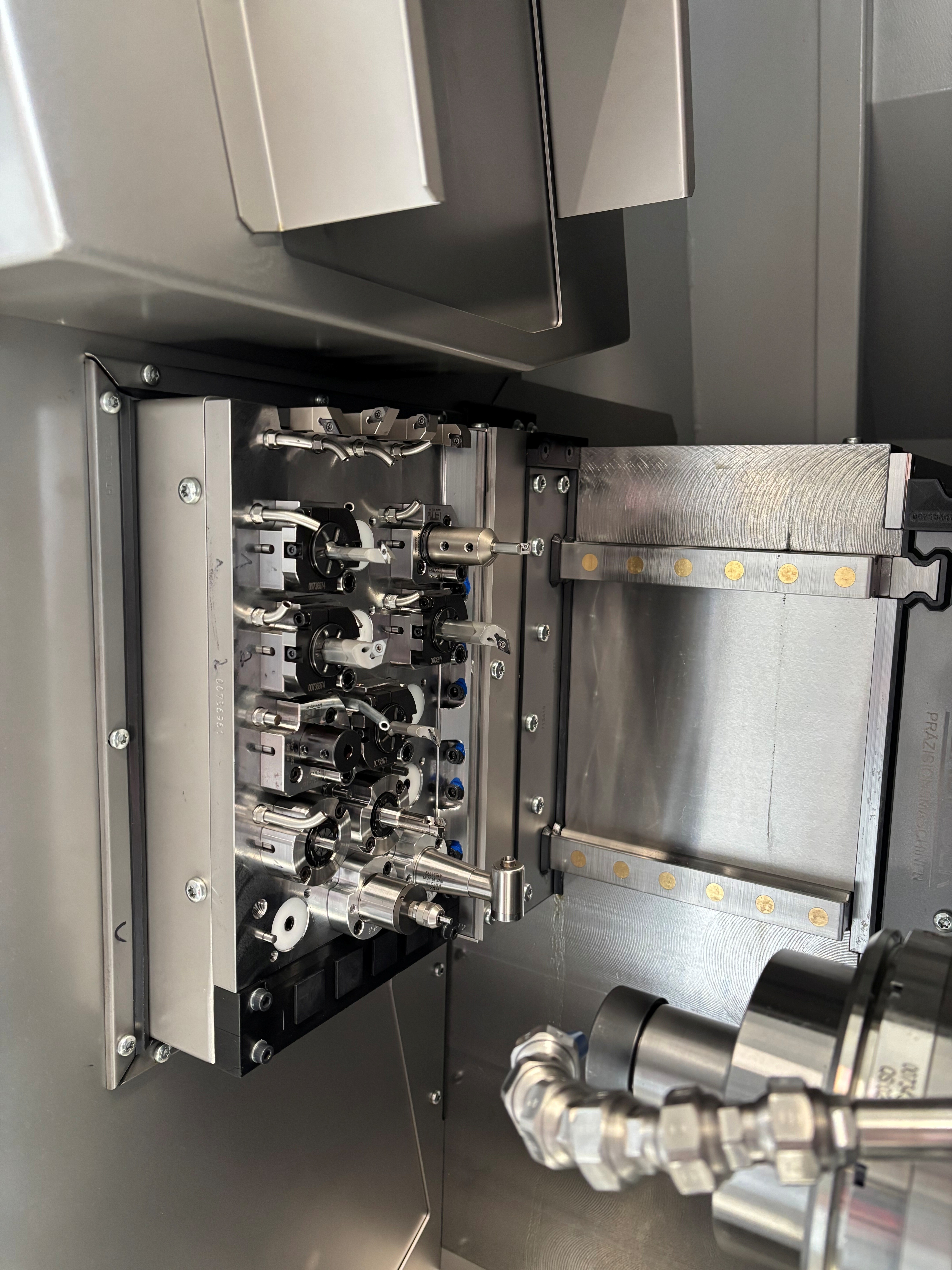 Close-up of Benzinger lathe tool turret assembly displaying multiple precision cutting tools and rigid machine construction